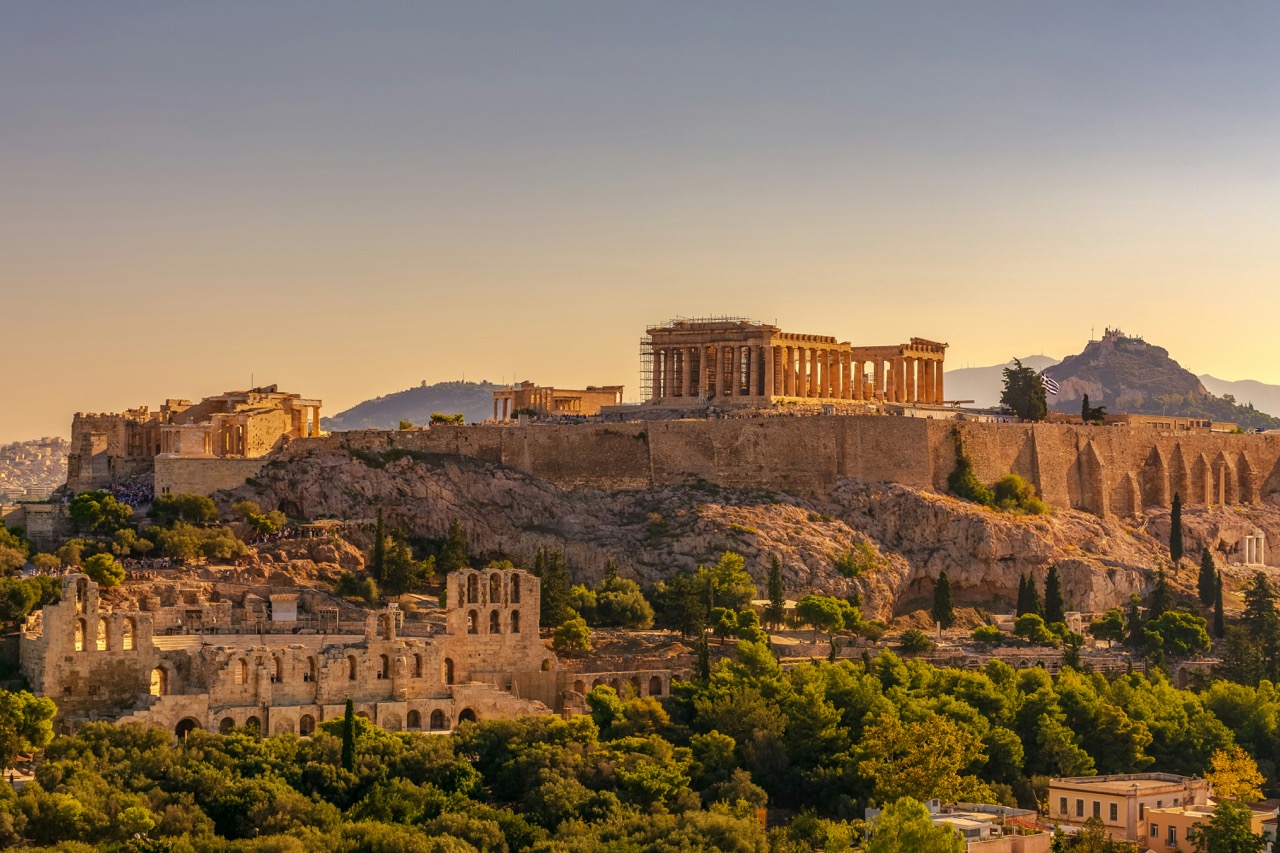 View of the Acropolis and surrounding area at sunset with a golden glow, capturing the essence of ancient Athens